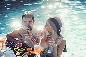 Couple of bearded man and woman with cocktail and fruit in miami. Summer vacation and swimming at sea. Cocktail at man