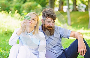 Couple bearded man and woman enjoy nature while sit on green grass meadow. Nature beauty concept. Woman enjoy relax