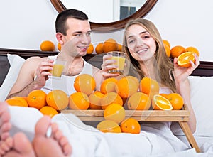 Couple in bed with orange fruits