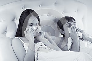 Couple in bed suffering common cold