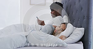 Couple, bedroom and husband with phone, texting and woman sleeping for rest or relaxation. Man, scrolling social media