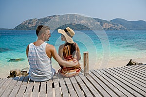 Couple from behind on the backside looking out over ocean of tropical Island, beautiful tropical island beach - Koh Kham