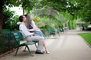 Couple on a bench, girl is whispering something