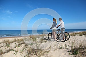 Couple with bicycles on the beach