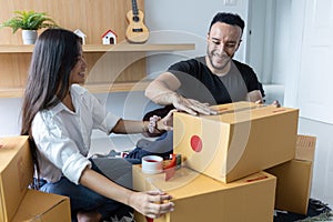 A couple with a big box in their new home. Carrying things into a new home