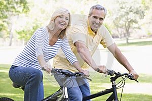 Couple on bikes outdoors smiling