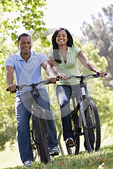 Couple on bikes outdoors smiling