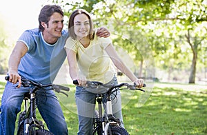 Couple on bikes outdoors smiling