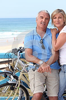 Couple biking by the seashore.