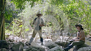 couple biologist on a forest walk collecting data is using binoculars