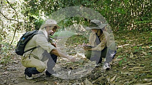 couple biologist on a forest walk collecting data is using binoculars to look into the treetops, conservation concept