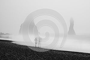 Couple on black beach, Iceland, in heavy fog