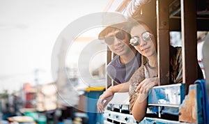 A couple of blogger tourists from Southeast Asia. Visit Phuket in Thailand are selfies on local bus. Captured in the old town of