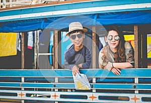 A couple of blogger tourists from Southeast Asia. Visit Phuket in Thailand are selfies on local bus. Captured in the old town of