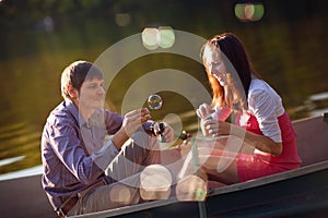 Couple in a boat with bubble blowers