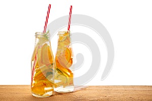 Couple of bottles lemonade with lemon, orange, lime, twig mint,