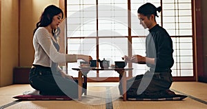 Couple, bow for hello and eating food, Japanese people on date with respect, culture and love together in Tokyo. Hungry