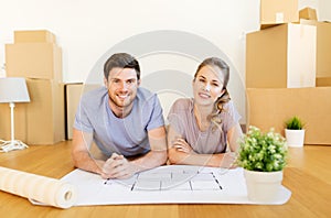 Couple with boxes and blueprint moving to new home