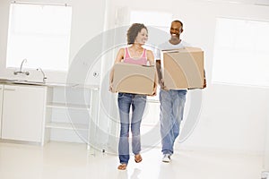 Couple with boxes moving into new home smiling