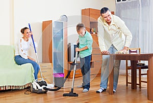 Couple and boy dusting together