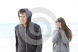 Couple break up on the beach with a man leaving girl photo