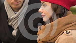 Couple breaking up quietly, man leaving woman, eyes down and feel sorrow closeup