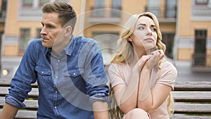 Couple breaking up, upset man and crying woman sitting on bench, divorce