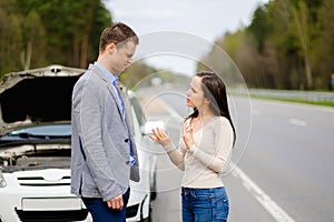 Couple and broken car on a highway