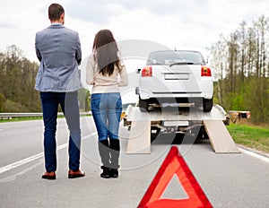 Couple and broken car on a highway