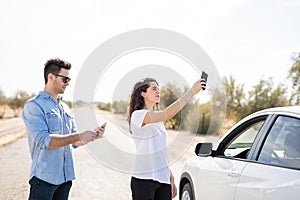 Couple with broken car searching for phone coverage