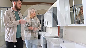 Couple browsing bathroom showroom with cabinetry and fixtures