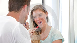 Couple Brushing Teeth In Bathroom Together