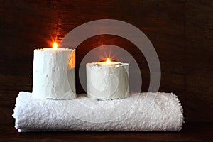 Couple burning candles in wooden easel and towel