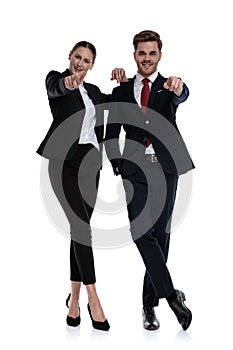 Couple in business suits pointing