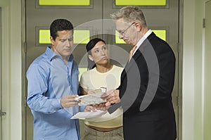 Couple And Businessman With Documents