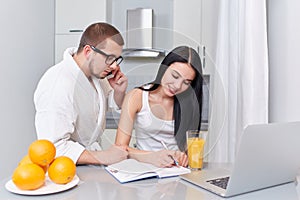 Couple of busy woman and man in morning at kitchen.