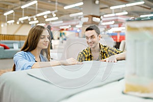 Couple buying blanket for bed in furniture store