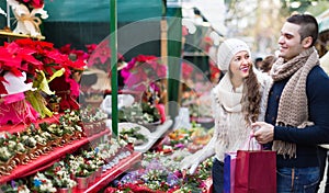 Couple buying Christmas flower at market