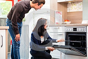 Couple buying domestic kitchen in showroom