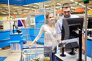 Couple buying food at grocery store cash register