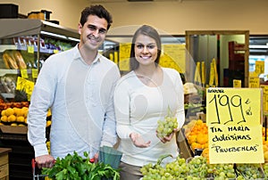 Couple buying fresh seasonal fruits in market