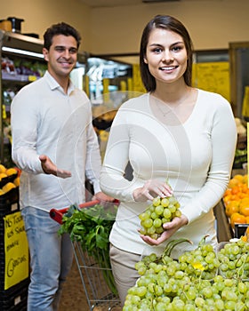 Couple buying fresh seasonal fruits in market