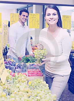 Couple buying fresh seasonal fruits in market