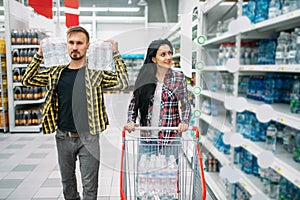 Couple buying mineral water in supermarket