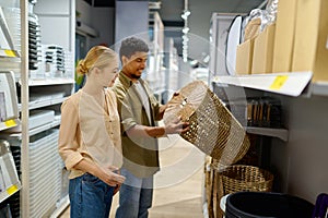 Couple buying wicker laundry basket at shop