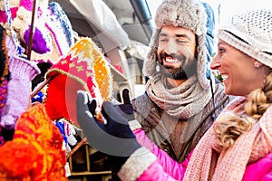 Couple buying winter clothes on Christmas market