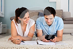 Couple Calculating Bills Together At Home