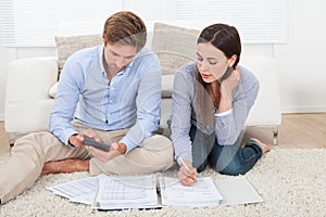 Couple calculating budget at home