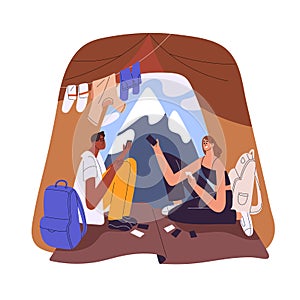 Couple campers in tent during mountain camping. Happy hikers tourists, man and woman relaxing, playing cards in nature