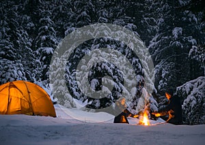 Couple camping with campfire and tent outdoors